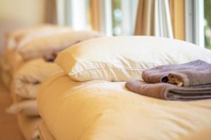 a row of pillows on a bed with a cat on them at SHINMINKA Villa JANADO - Vacation STAY 66320v in Kumejima