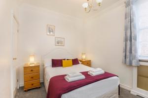 a bedroom with a bed with towels on it at Shambles Suites in the centre of York, sleeps 16 in York