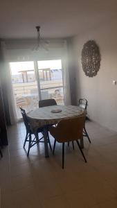 uma mesa de jantar e cadeiras num quarto com varanda em Apartamento Andalucía - vistas al mar, playa, puerto deportivo, garaje em Garrucha