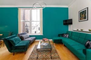 a living room with blue walls and a green couch at Shambles Suites in the centre of York, sleeps 16 in York