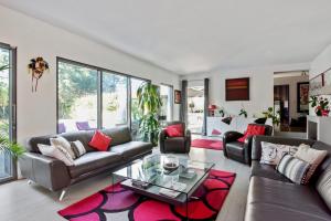ein Wohnzimmer mit einem Sofa und einem Glastisch in der Unterkunft Villa des Puits - Welkeys in La Celle-Saint-Cloud