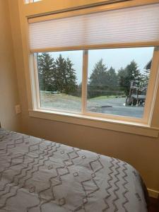 1 dormitorio con ventana y vistas al patio en Delightful Tiny Home w/ 2 beds and indoor fireplace, en McKinleyville