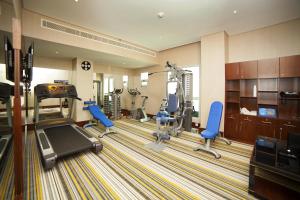 a fitness room with a gym with a treadmill and chairs at Raviz Center Point Hotel in Dubai