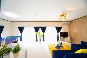 Yokkaichi - House - Vacation STAY 14171 في يوكايتشي: غرفة معيشة مع أريكة زرقاء وتلفزيون