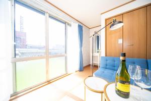 Yokkaichi - House - Vacation STAY 68045v في يوكايتشي: زجاجة من النبيذ موضوعة على طاولة في غرفة المعيشة