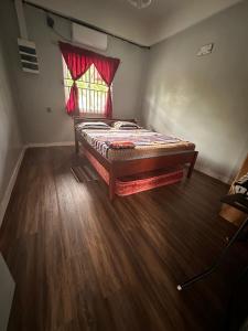 Bett in einem Zimmer mit Buntglasfenster in der Unterkunft Zeedijk Resort Nickerie in Nieuw Nickerie