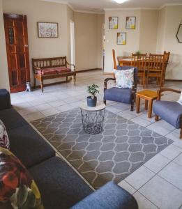 sala de estar con sofás, sillas y mesa en Habitat Place, en Bloemfontein