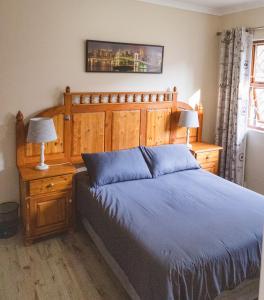 a bedroom with a large bed with a wooden headboard at Habitat Place in Bloemfontein