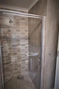 La salle de bains est pourvue d'une douche et d'un lavabo. dans l'établissement Habitat Place, à Bloemfontein