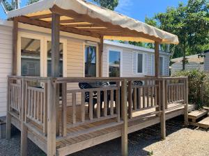 a large wooden deck with a pergola at Mobilhome 5 VO32 in Vias