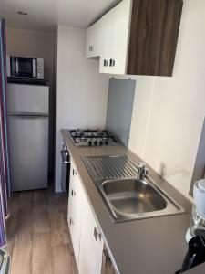 małą kuchnię ze zlewem i lodówką w obiekcie Mobilhome 5 VO32 w mieście Vias
