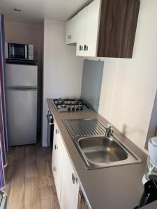 a small kitchen with a sink and a refrigerator at Mobilhome 5 VO32 in Vias