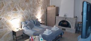 a bedroom with a bed and a fireplace at Lovely Studio in Strinilas with its own pool in StrinÃ½las