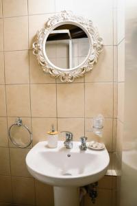 uma casa de banho com um lavatório e um espelho na parede em Archontiko Rousias em Nicósia