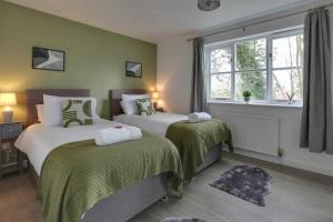 - une chambre avec 2 lits aux murs verts et une fenêtre dans l'établissement Entire home/flat perfect for contractors, à Bishop's Stortford