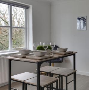 a dining room table with four chairs and wine glasses at Entire home/flat perfect for contractors in Bishops Stortford