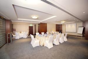 a conference room with white tables and white chairs at Raviz Center Point Hotel in Dubai +37 photos
