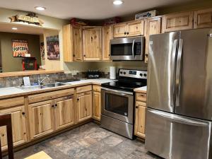 a kitchen with wooden cabinets and stainless steel appliances at Lovely county-fair getaway in Redmond