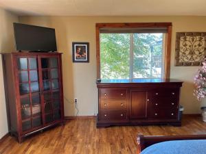 a living room with a large wooden dresser and a television at Lovely county-fair getaway in Redmond