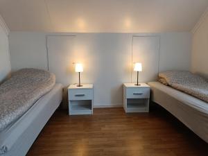 two beds in a room with two lamps on them at Reinebu in Ørsta