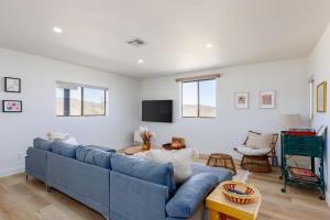 een woonkamer met een blauwe bank en een tv bij Los Tres Coyotes in Twentynine Palms