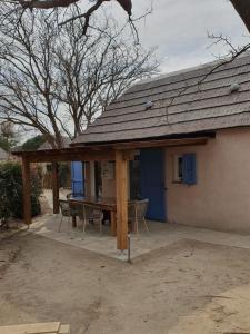 un pabellón con mesa y sillas frente a una casa en Fischerhaus 1950, en Le Barcarès