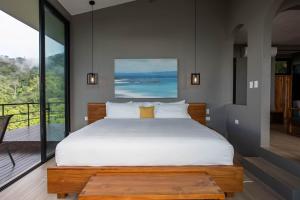 a bedroom with a large bed and a balcony at Rancho Pacifico - Boutique Hotel for Adults in Uvita