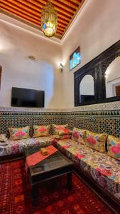 a living room with a couch and a tv at Dar La Bague de Kenza in Fez