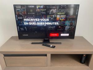 a tv sitting on top of a table with a remote control at Maison proche du centre ville de la gare l aéroport de Charleroi in Charleroi