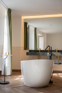 a bathroom with a large white tub in front of a mirror at Hotel Boutique Las Indianas in Nueva de Llanes