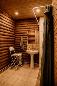 a bathroom with a sink and a chair at Kempings Adamova 