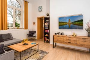 uma sala de estar com um sofá e uma televisão na parede em Apartment Westend em Markranstädt