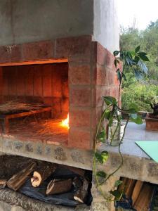 un horno de ladrillo con un fuego dentro de él en Valle del Yuspe en Cosquín