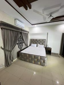 - une chambre avec un grand lit et un rideau dans l'établissement Oriole Luxury Hotel, à Islamabad