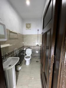 La salle de bains est pourvue de toilettes et d'un lavabo. dans l'établissement Oriole Luxury Hotel, à Islamabad