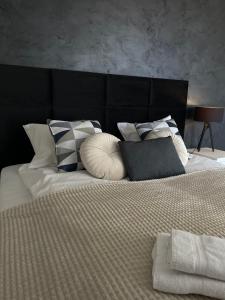 a bed with a bunch of pillows on it at No 59 Apartament in Nowy Targ