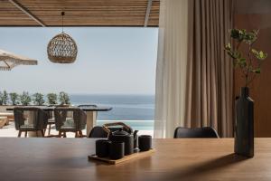 a dining room table with a view of the ocean at Limnionas Infinity Cave Villa in Kampíon
