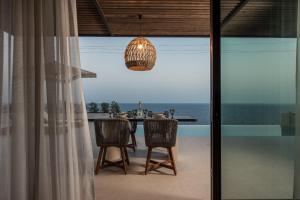 a dining room with a view of the ocean at Limnionas Infinity Cave Villa in Kampíon