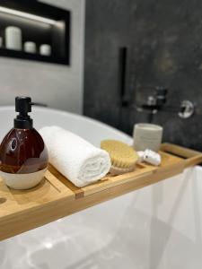 bandeja de madera con toallas y una botella de jabón en No 59 Apartament, en Nowy Targ