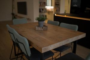 uma mesa de madeira com cadeiras e um vaso de plantas sobre ela em Casa Casver em Deltebre