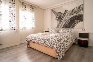 a bedroom with a bed with a poster of the eiffel tower at Bonito, Práctico y muy bien comunicado in Madrid