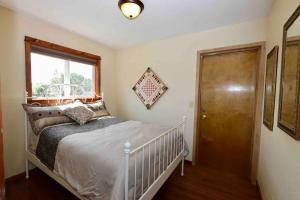 a bedroom with a bed and a window and a door at Hidden gem close to fairgrounds in Redmond