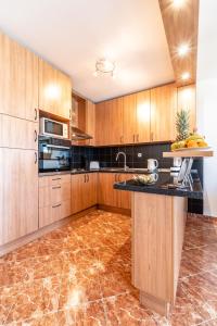 a kitchen with wooden cabinets and a marble floor at Apartment Mia in Sutivan