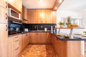 uma cozinha com armários de madeira e bancadas pretas em Apartment Mia em Sutivan