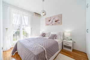 biała sypialnia z łóżkiem i oknem w obiekcie Apartment Mia w mieście Sutivan