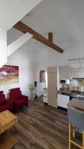 a living room with a red couch and a kitchen at Ferienwohnung Lattenberg in Bayerisch Gmain