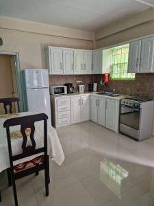 a kitchen with white cabinets and a white refrigerator at My Gem in the Caribbean in Castries