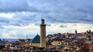 un edificio alto con una torre de reloj en una ciudad en Dar La Bague de Kenza, en Fez