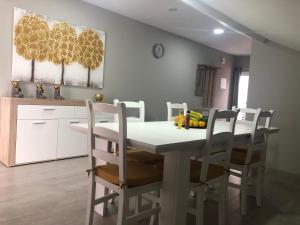 a dining room with a white table and chairs at Casa das Palmeiras in Calheta