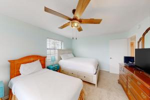 a bedroom with two beds and a ceiling fan at A Pirate's Paradise in Galveston